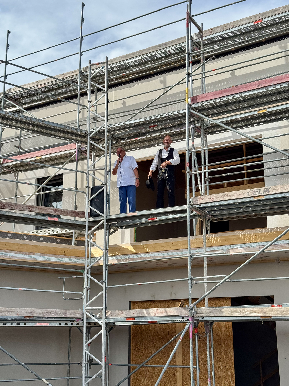 The property owner delivers an enthusiastic speech on the scaffolding of the new building